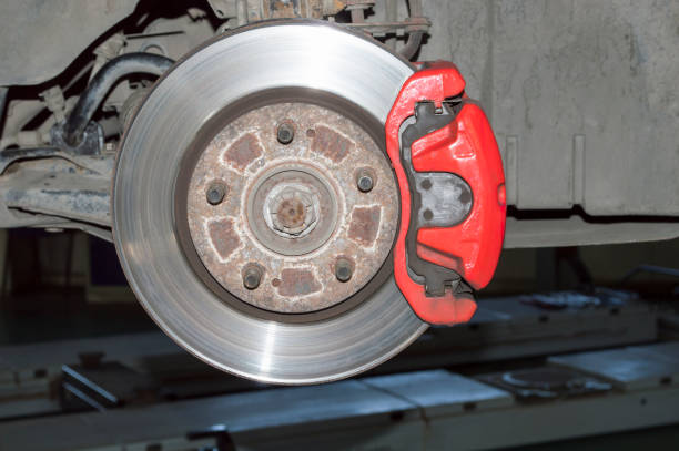 istock Red brake caliper mounted on the car's brake disc 1359737583