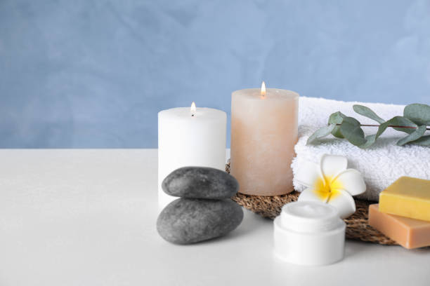 istock Composition with cream and burning candles on white table. Spa treatment 1359740819