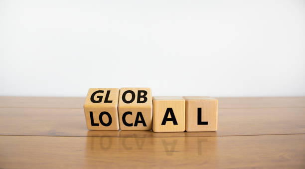 Local or global symbol. Turned wooden cubes and changed the word 'local' to 'global'. Beautiful wooden table, white background. Business and local or global concept. Copy space. stock photo