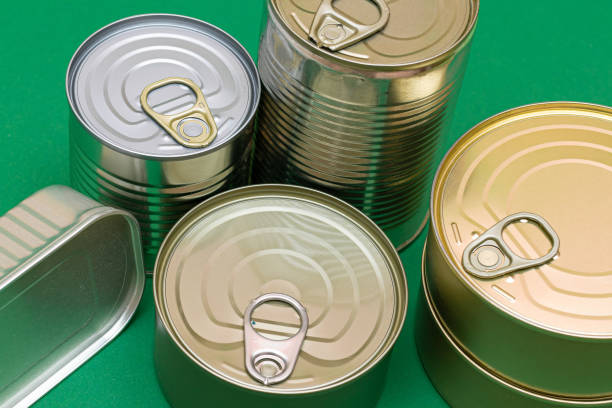 istock Unopened Tin Cans with Blank Edges on Green Background 1359741697
