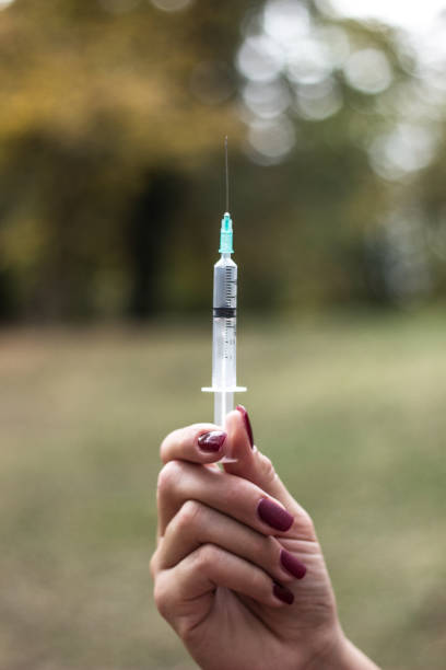 istock Woman addicted with syringe injecting 1359744822