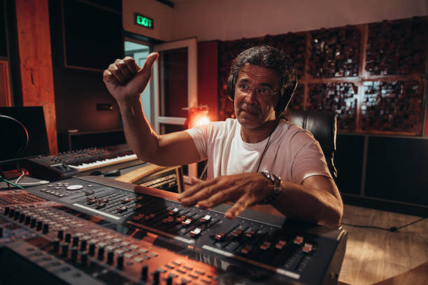 istock Senior hispanic music producer working on a mixing soundboard while in his studio 1359748820