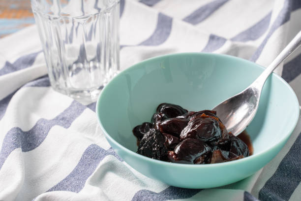 easy stewed prunes cooked dry plum fruit in a bowl on the table stock photo
