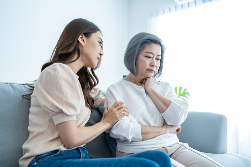 Asian loving daughter comforts upset elderly mother crying for problem. Young caring woman support, consoling and understand empathy to stressed senior older mom in tears at home. Family relationship.