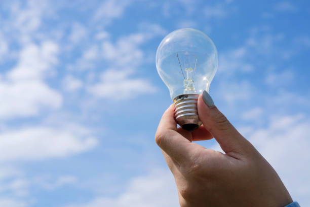 istock concept power energy in nature. hand holding lightbulb with solar 1359778010