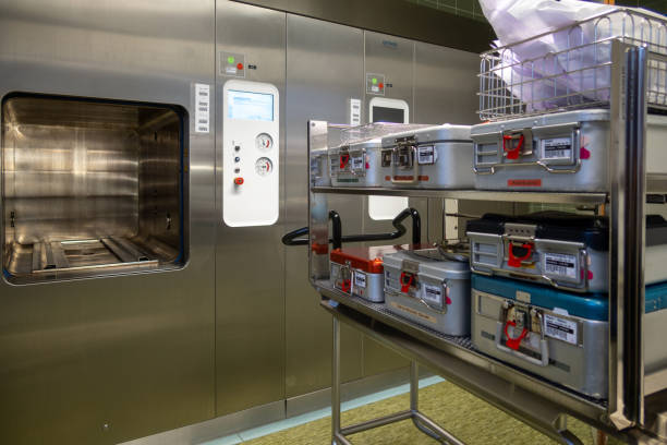 a trolley loaded with instrument containers is pushed into a steam sterilizer - sterilizer imagens e fotografias de stock