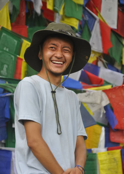 istock A happy tibetan young man looking sideways, standing against Buddhist prayer flags 1359785909