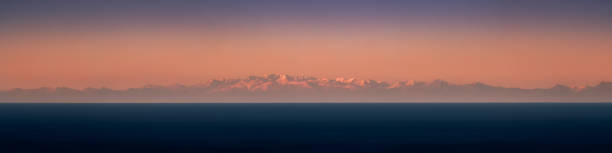 The Alps viewed from Corsica at dusk stock photo