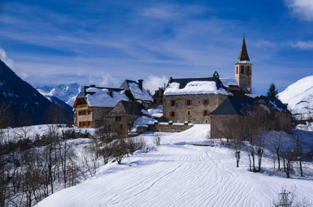 Aran Valley in winter. In the foreground, the village of Unha. In the background, Aneto peak with the Maladeta range (Aran Valley, Pyrenees, Catalonia, Spain) stock photo
