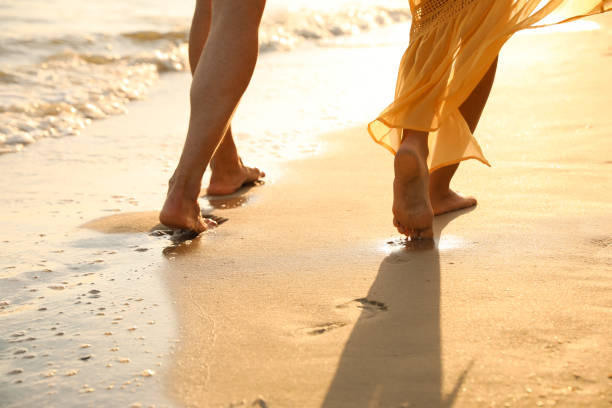 istock Couple walking together on beach, closeup view 1359788603