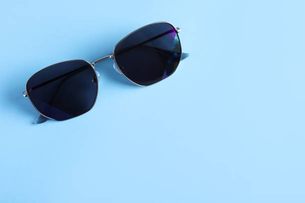 istock Stylish sunglasses on light blue background, top view. Space for text 1359789237