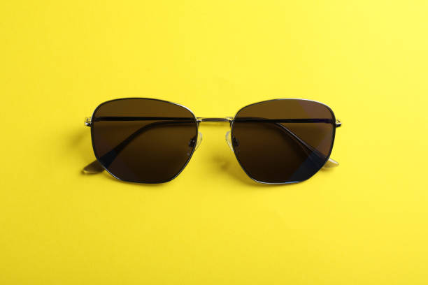 istock Stylish sunglasses on yellow background, top view 1359789500