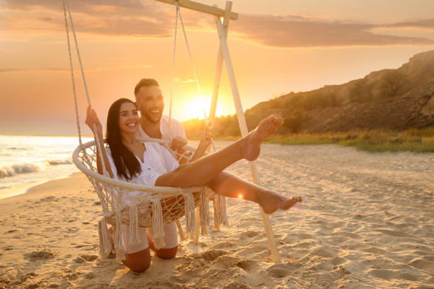 istock Happy young couple on beach at sunset 1359790135