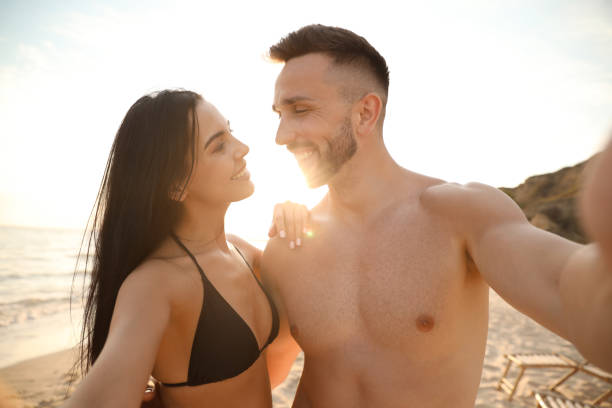 istock Happy young couple taking selfie on beach at sunset 1359791108