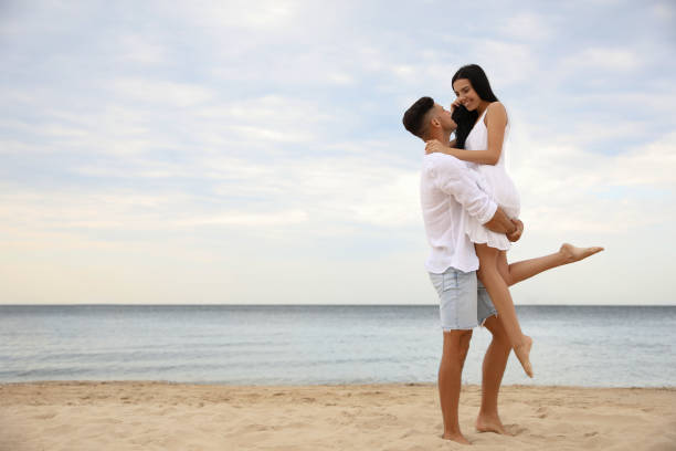 istock Lovely couple having fun on beautiful beach. Space for text 1359796661