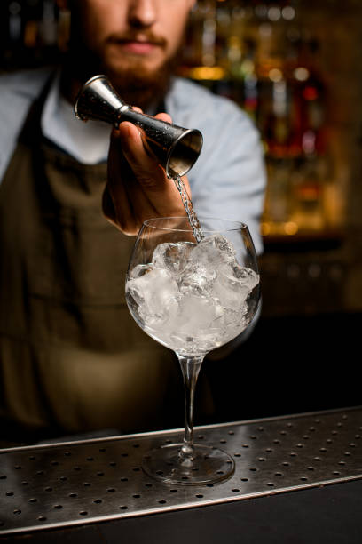 istock clear wine goblet glass in which bartender gently pours liquid from jigger 1359798841