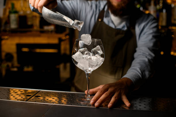 istock clear wine goblet glass in which bartender gently pours ice cubes from a scoop 1359799828