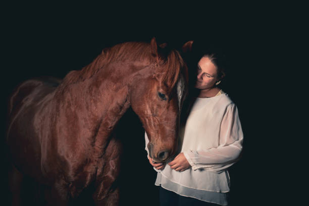 istock Woman With Her Horse, studio shot on black background. 1359806547