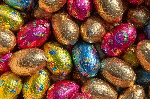 Full-frame close-up on a stack of colorful foil wrapped chocolate Easter eggs