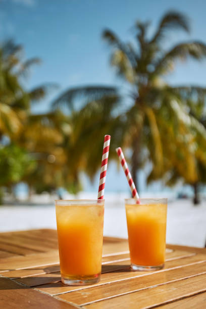 dos refrescantes bebidas frías en la playa de arena blanca - anticipation outdoors close up nobody fotografías e imágenes de stock