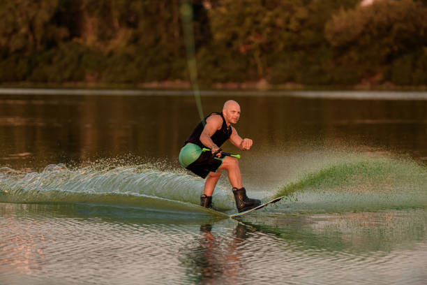 istock active muscular man holds rope and skilfully balancing on water on wakeboard 1359809267