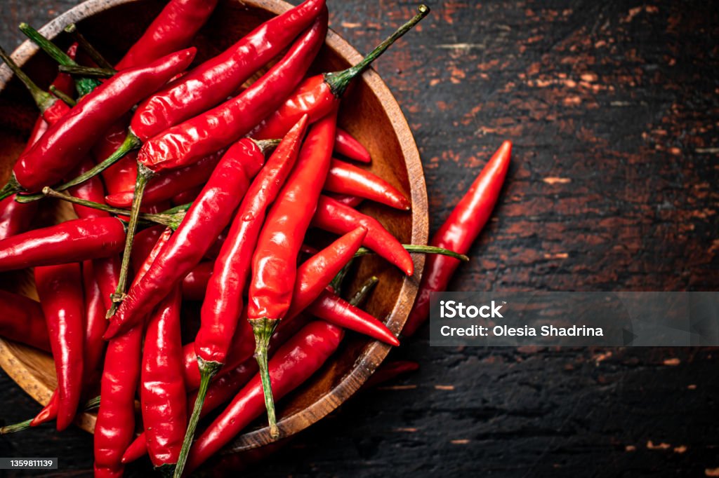 Wooden plate with hot chili peppers. Wooden plate with hot chili peppers. On a rustic dark background. High quality photo Chili Pepper Stock Photo