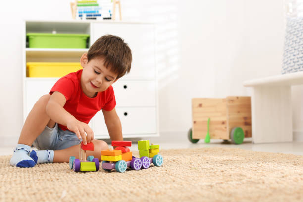 lindo niño jugando con juguetes coloridos en el piso de la casa, espacio para el texto - niño pequeño fotografías e imágenes de stock