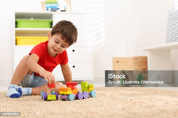 Cute Little Boy Playing With Colorful Toys On Floor At Home Space For Text Stock Photo - Download Image Now
