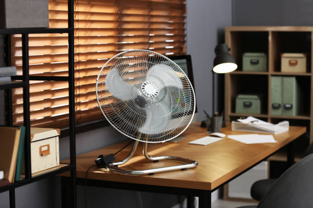 istock Modern electric fan on table in office 1359815066