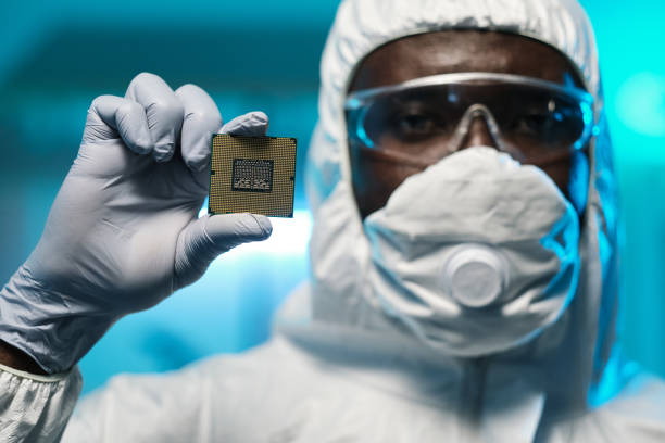 istock Gloved hand of young African scientist holding microchip 1359815814