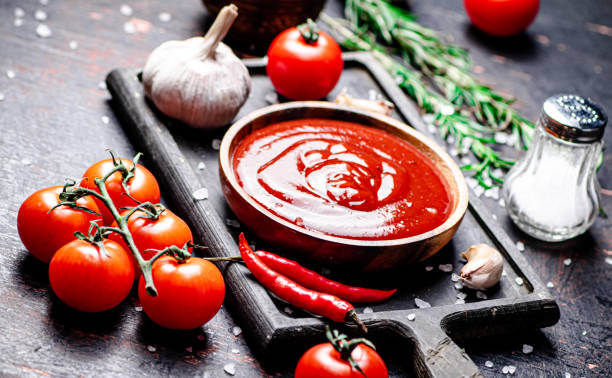 istock Tomato sauce on a cutting board with red pepper, garlic and rosemary. 1359817864