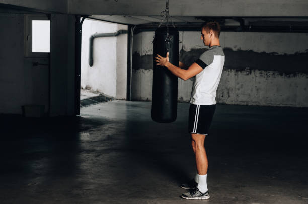istock Fit man preparing punching bag in garage 1359818525