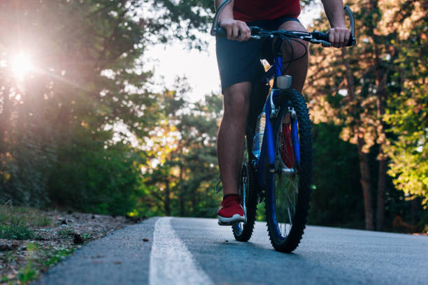 istock Tall handsome biker rides his bicycle on sunset in a lovely magical forest. 1359819297