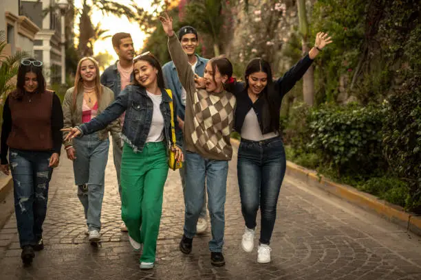 Photo of Teenager friends walking and dancing outdoors