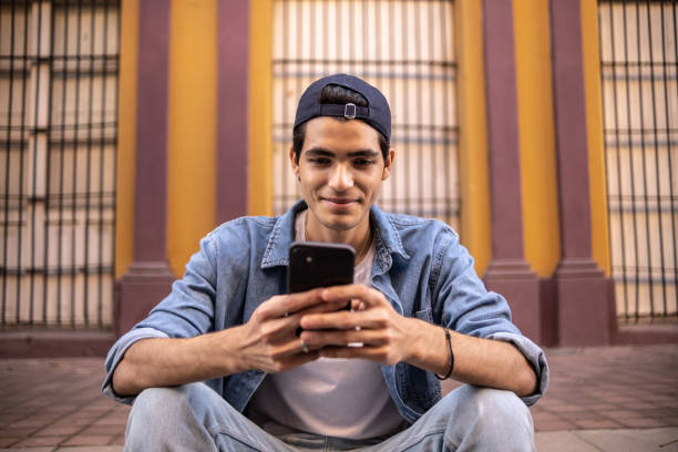 istock Teenager boy using the mobile phone outdoors 1359819694
