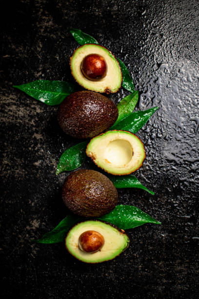 istock Fresh avocado with leaves. On a black background. 1359822981