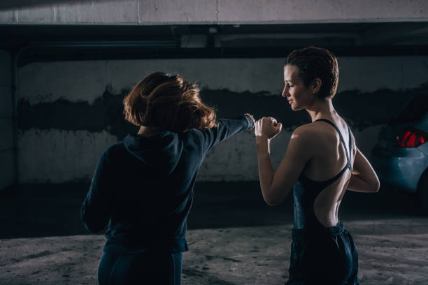 istock Silhouette picture of two young women practicing fighting inside the garage. 1359824935