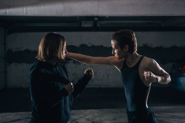 istock Silhouette picture of two young women practicing fighting inside the garage. 1359824939