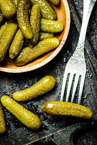 istock Wooden plate with pickles. On a black background. 1359826536