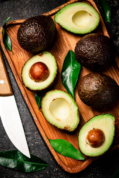 istock Fresh avocado with foliage on a cutting board. 1359827823
