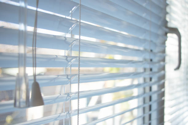 istock Sunlight coming through venetian blinds by the window 1359827877