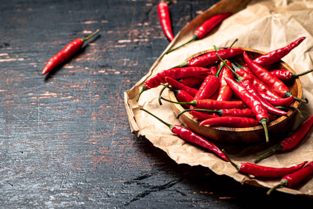istock Wooden plate with hot chili peppers. 1359828893