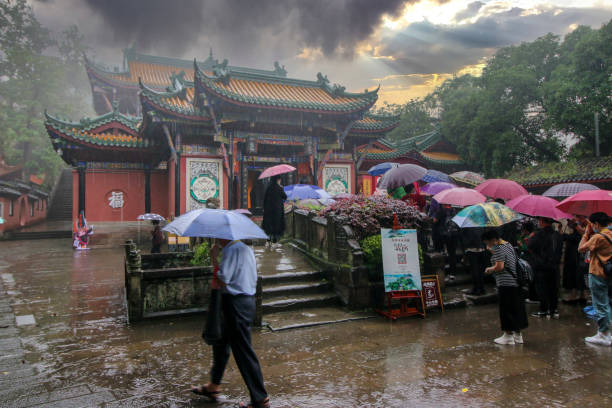 June 6, 2021 - Fengdu, China:  Visitors line up in the rain to visit a temple in the historic part of the city.