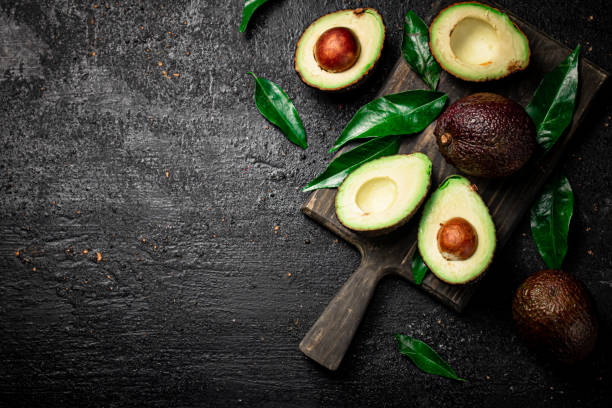 istock Fresh avocado with foliage on a cutting board. 1359833382