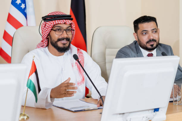 istock Young confident Arabian delegate speaking in microphone at conference 1359833714