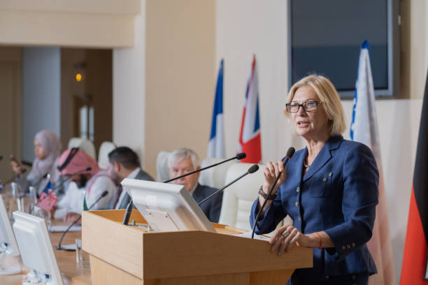 istock Mature female speaker in elegant suit making report 1359833731