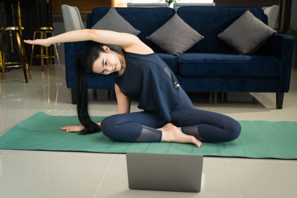 istock A young beautiful Asian woman learning physical exercise and workout online training program on a computer laptop at home 1359834593