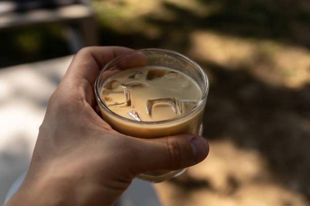 istock man keep a glass of iced coffee on summer terrace 1359836114
