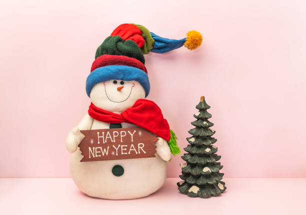 istock snowman with happy happy new year text board on pink background 1359836145