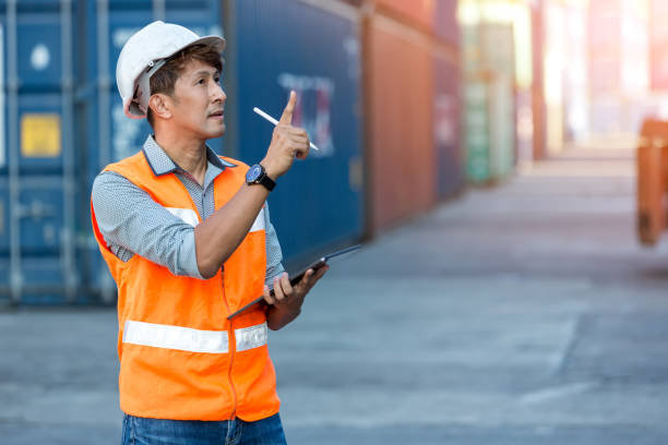 contremaître ou ouvrier tenant une tablette à main pour écrire et enregistrer les marchandises dans le conteneur sur le site de fret du conteneur. - 15805 photos et images de collection